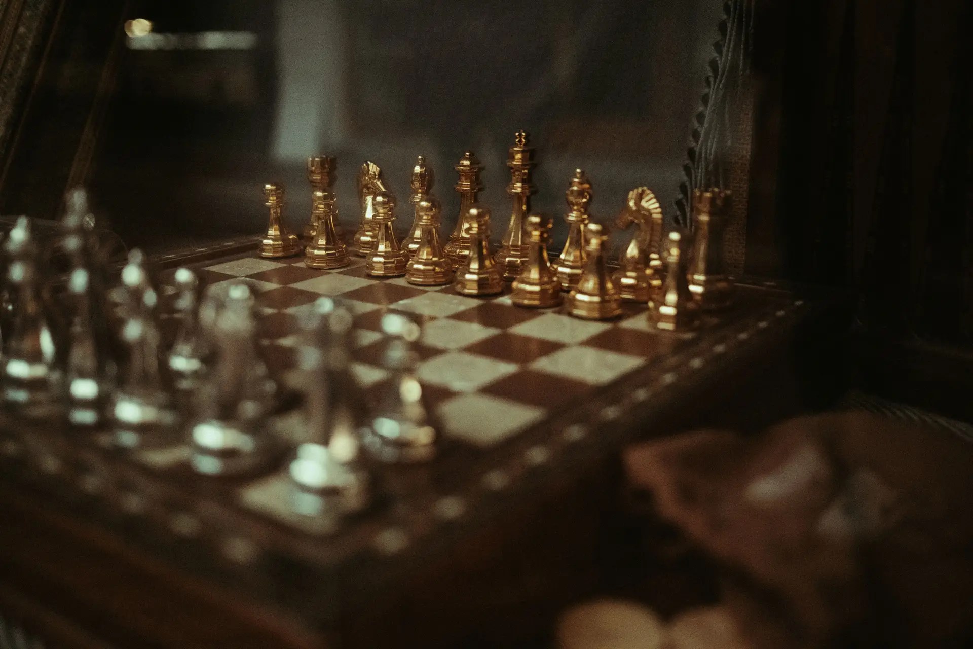 Ornate silver and gold chess pieces on a wooden board